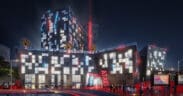 A rendering of the outside of the new Phoenix Atari Hotel coming in 2026 lit up at night.