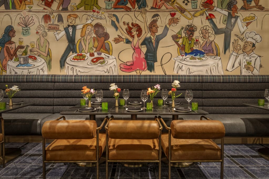 Booth seating with a lively restaurant cartoon mural and table set for a meal at The Americano.