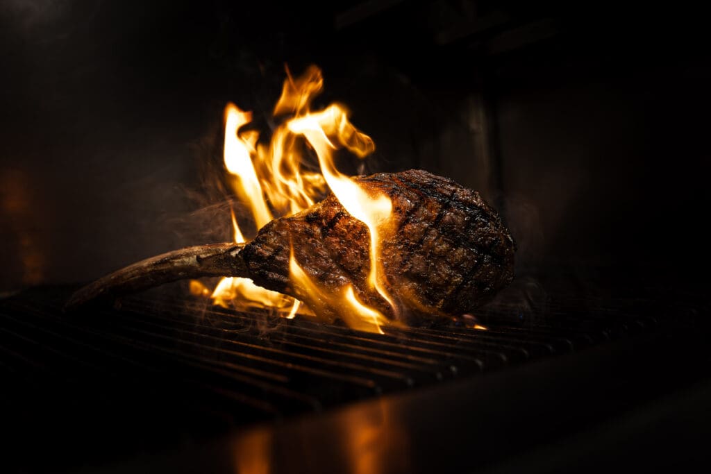 A ribeye over a flaming grill at BOA Steakhouse in Scottsdale, Arizona.