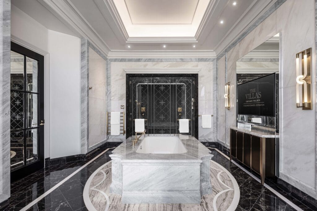 Luxury marble bathroom in a Colosseum Presidential Villa at Caesars Palace with soaking tub and gold fixtures.