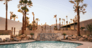 The pool at Kimpton Miralina Resort & Villas Paradise Valley surrounded by rocks and palm tree landscaping.