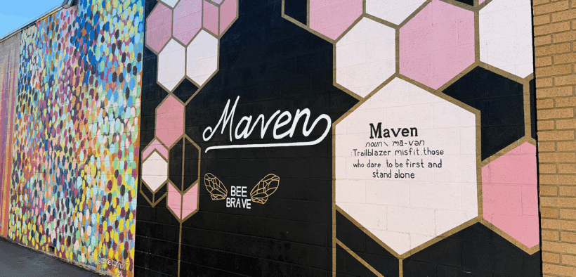 A mural wall of the Maven District in Salt Lake City resembling a beehive with an inspirational quote.
